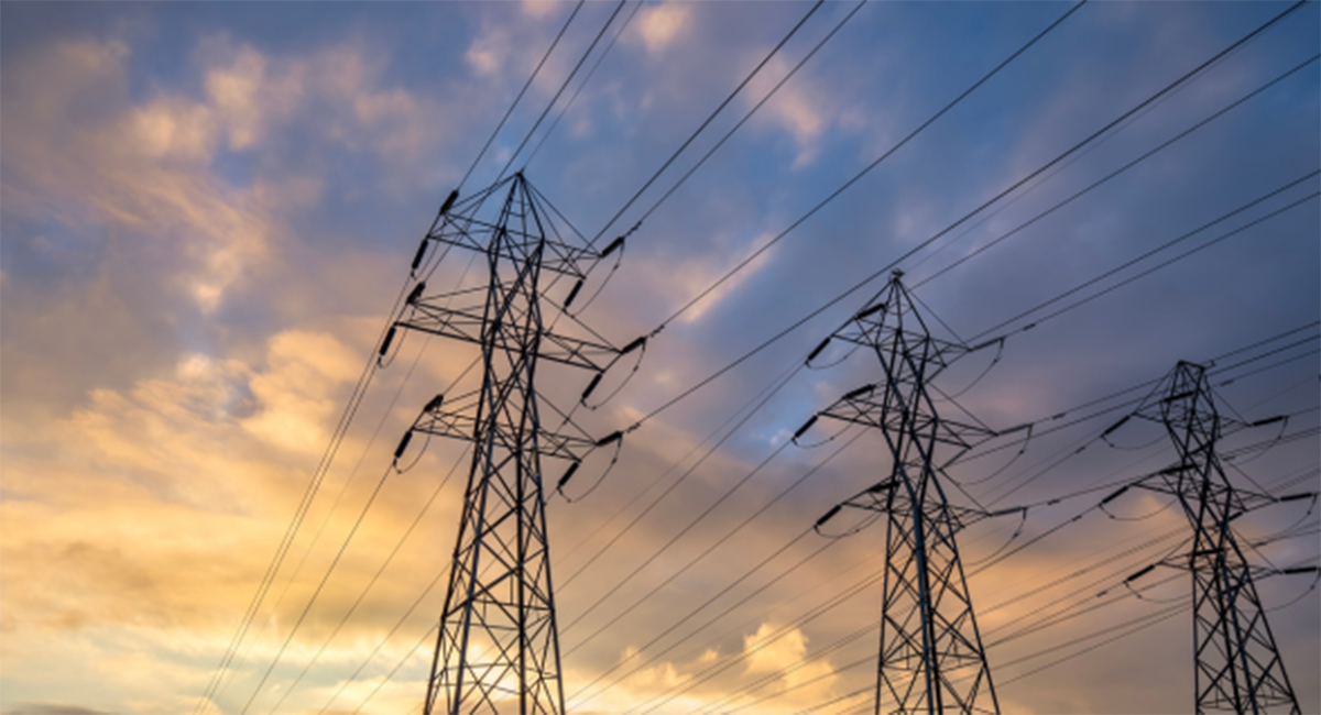 Transmission lines against a partly cloudy sunset sky.