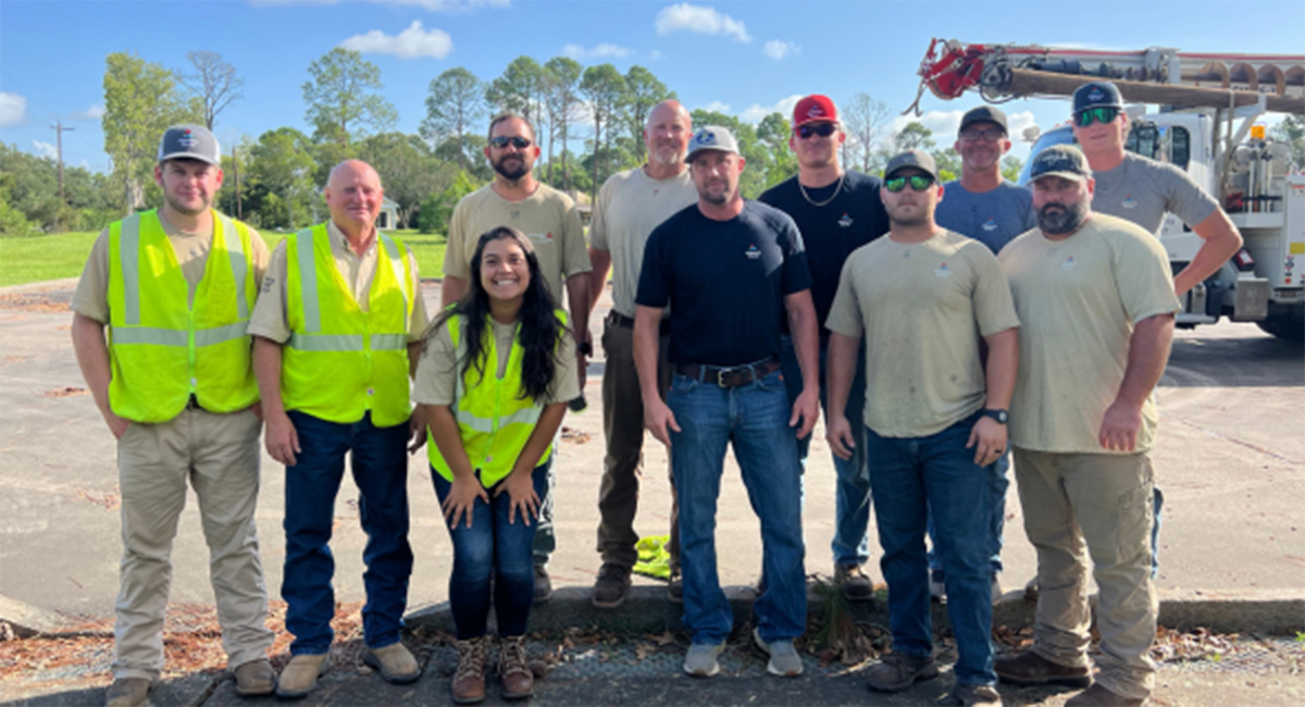 A group of Alabama Power employees pose in front of a service vehicle.