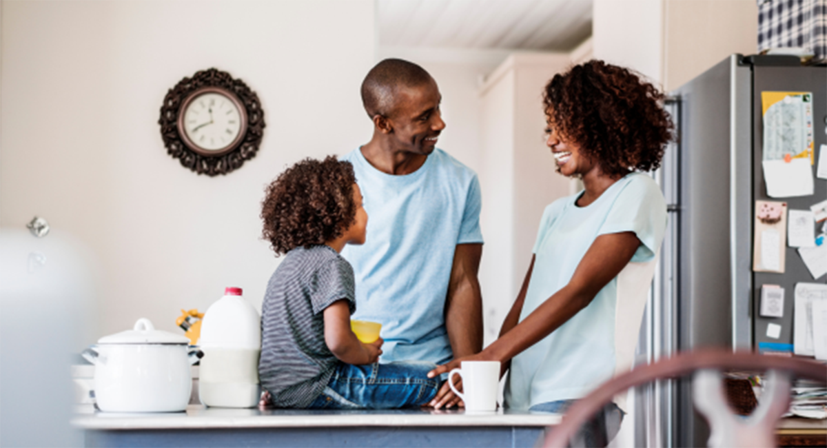 A young family gathers in the kitchen.