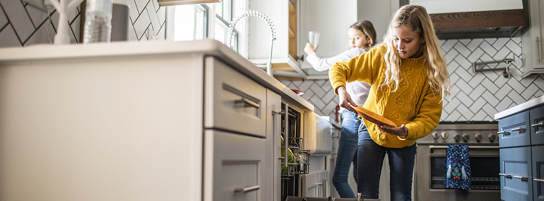 1376105931 Tween girls doing dishes in modern kitchen